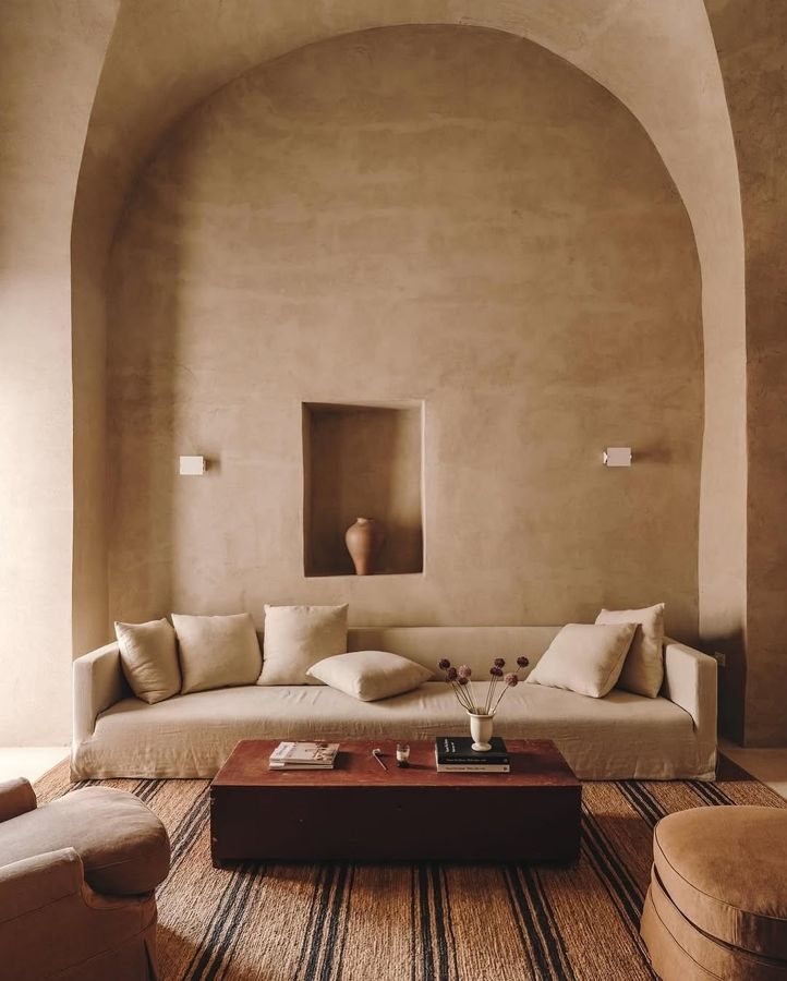A quiet living room in warm plaster with a low sofa