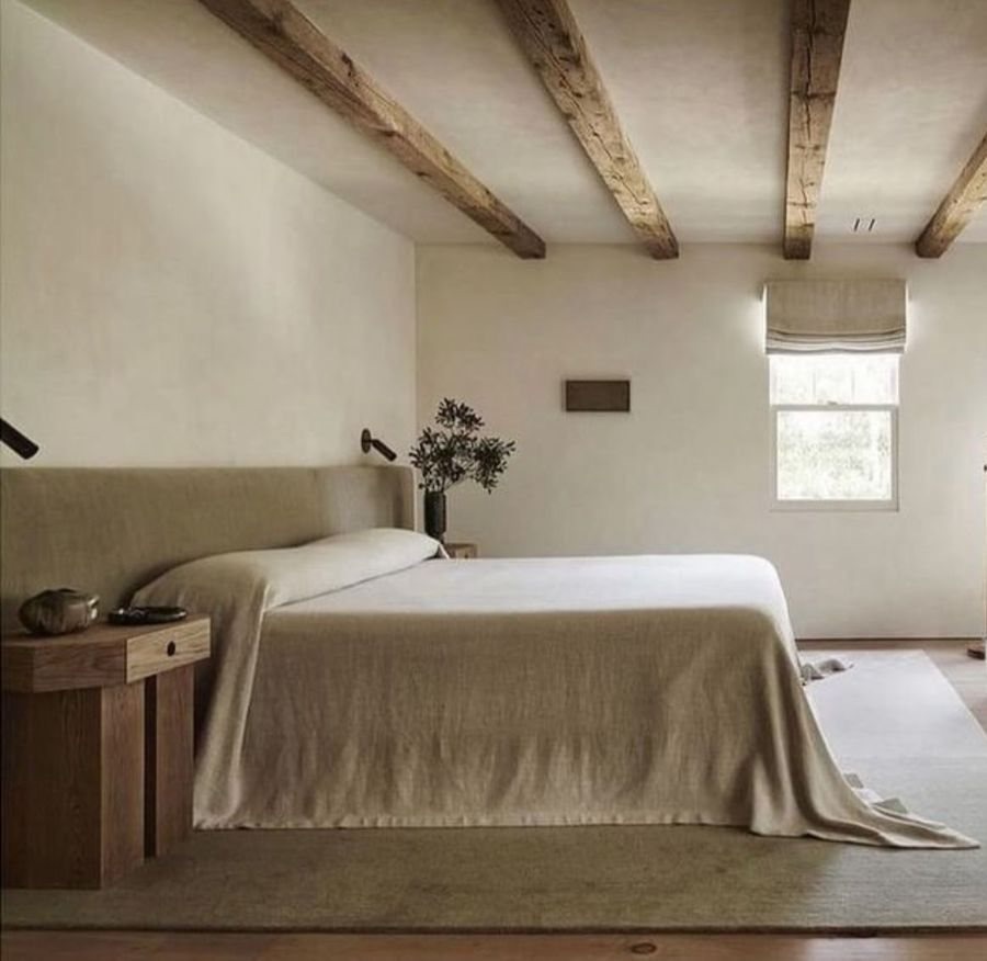 A calm bedroom under old wooden beams