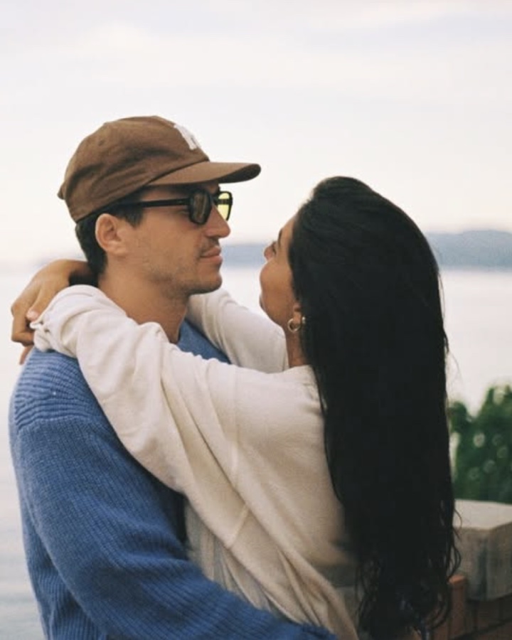 Lygia and Alex embracing on a terrace above the sea